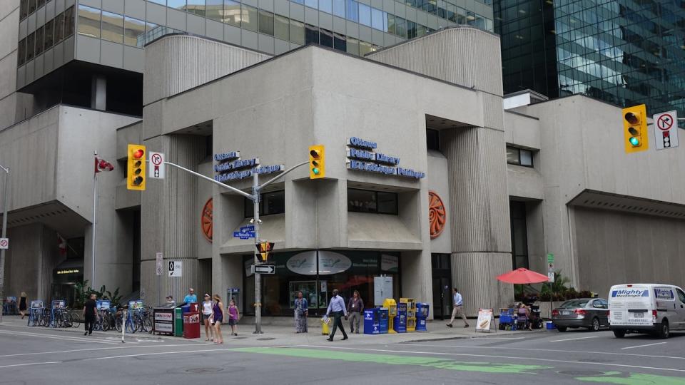 Pedestrians walk in front of the Ottawa Public Library's central branch.