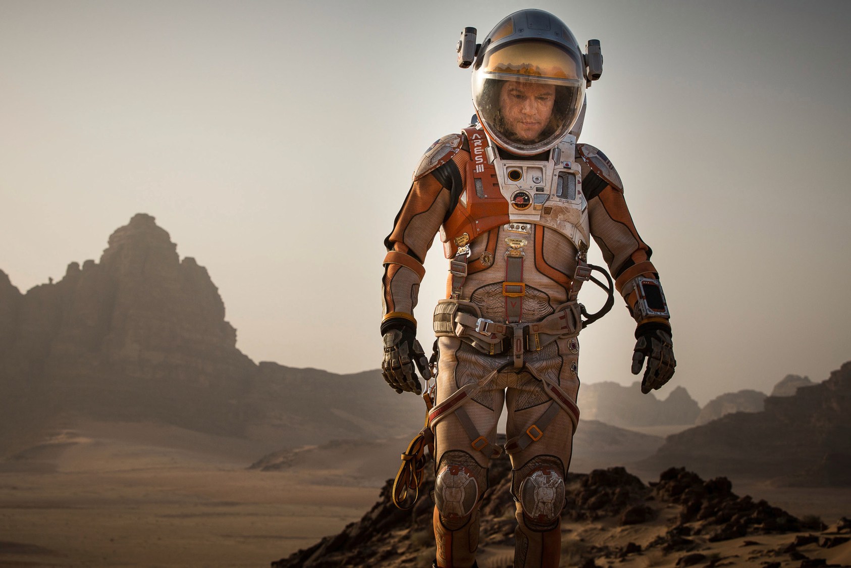 Matt Damon in a spacesuit on a Martian landscape.