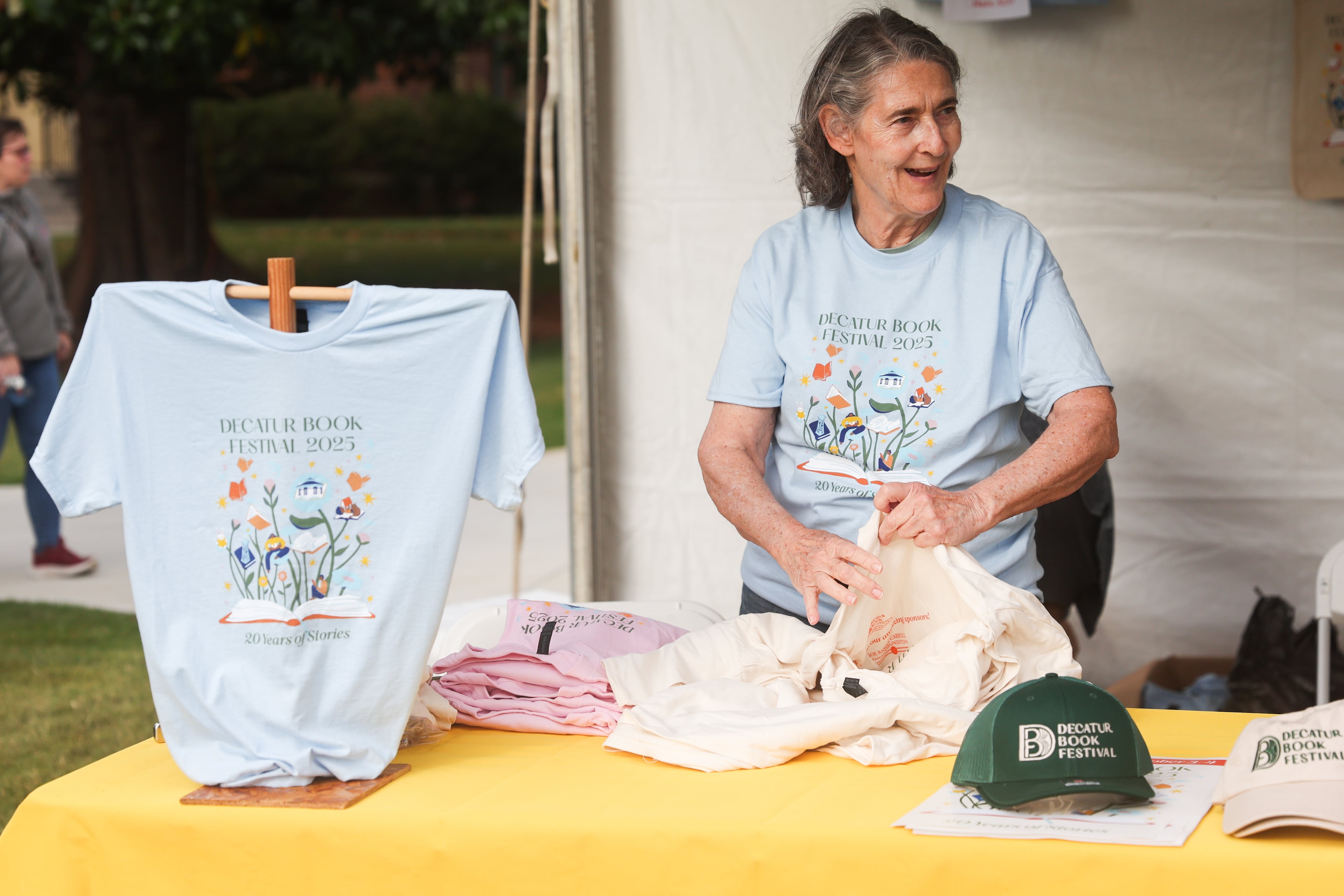 A volunteer folds festival T-shirts during the Decatur Book Festival at First Baptist Church of Decatur on Saturday, Oct. 4, 2025. (Abbey Cutrer/AJC)