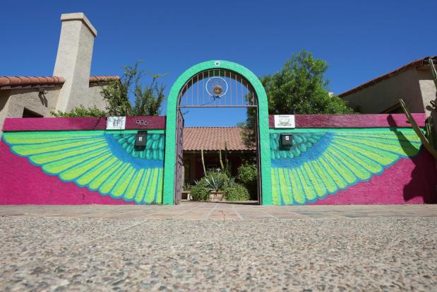 The main entrance of Palabras Bilingual Bookstore shows off colorful artwork, a theme throughout the bookstore, Monday, Oct. 6, 2025, in Phoenix. (AP Photo/Ross D. Franklin)