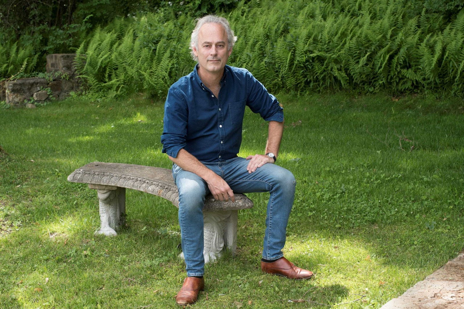 A man sitting on a bench in a garden
